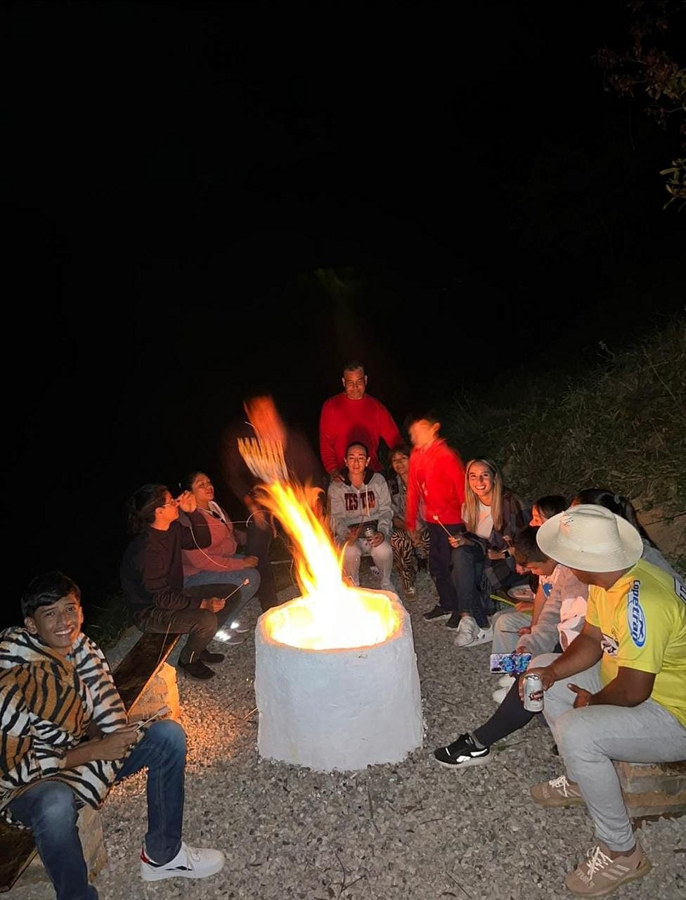 Grupo de huéspedes alrededor de la fogata en la noche