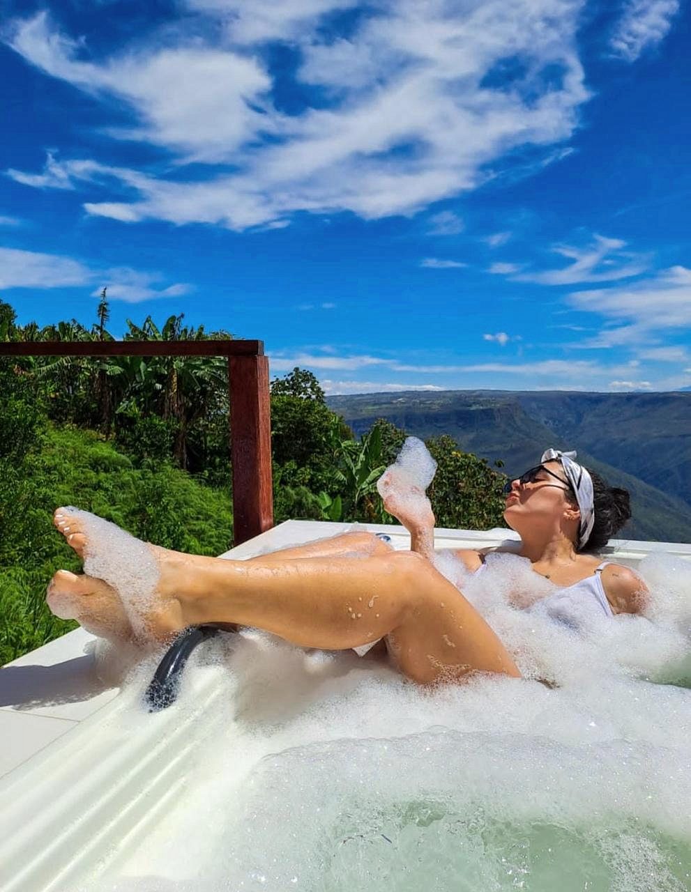 Huésped en el jacuzzi con espuma frente al cañón