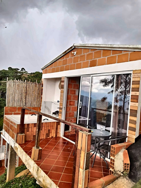Terraza con jacuzzi privado y comedor exterior en Glamping Clavellinas, Aratoca