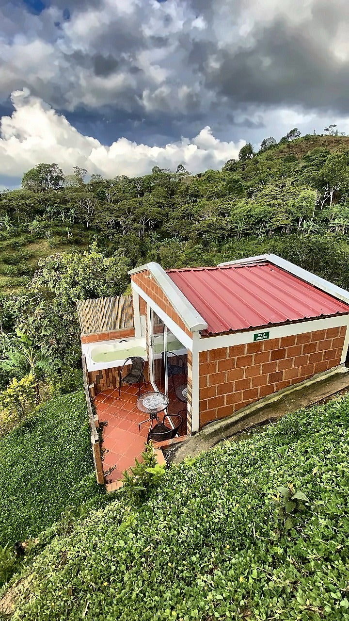 Glamping con jacuzzi visto desde arriba, rodeado de montaña en Aratoca