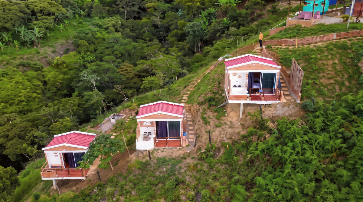 Las tres cabañas de Glamping Clavellinas en la ladera, vistas desde un dron