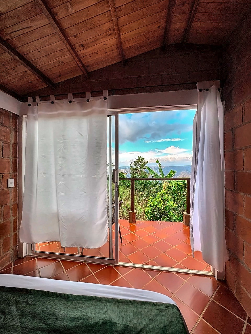 Vista a las montañas del Cañón del Chicamocha desde la cama, con puerta corrediza al balcón