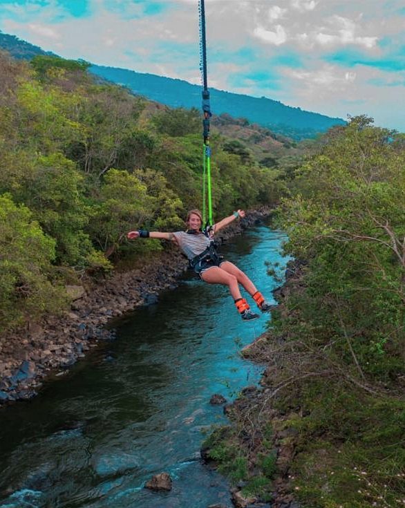 Persona saltando en puenting sobre un río